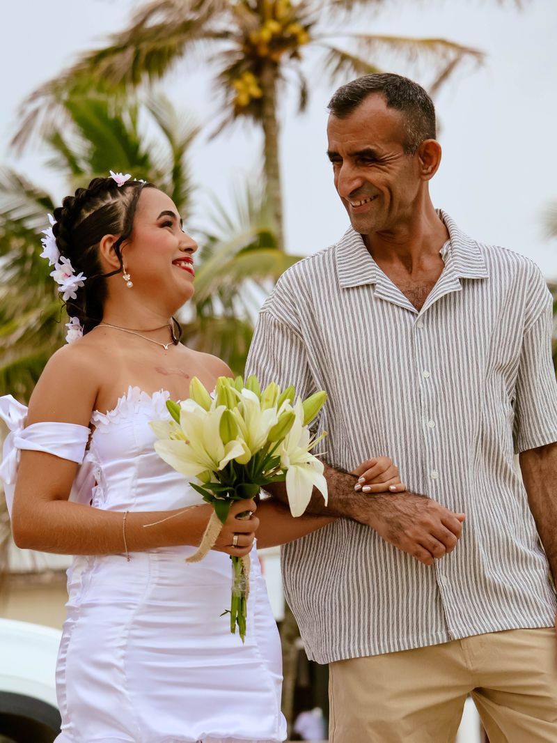 Noiva sorrindo ao lado do pai antes da cerimônia de casamento