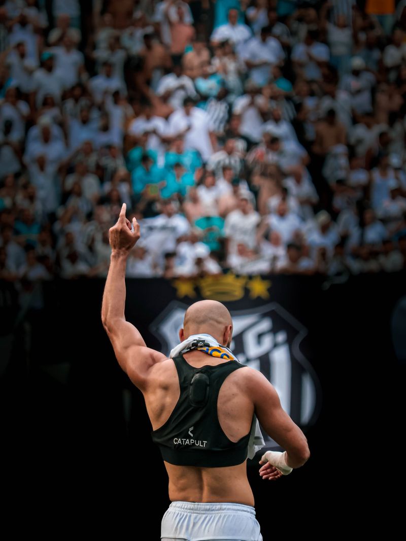 Jogador comemorando diante da torcida no estádio